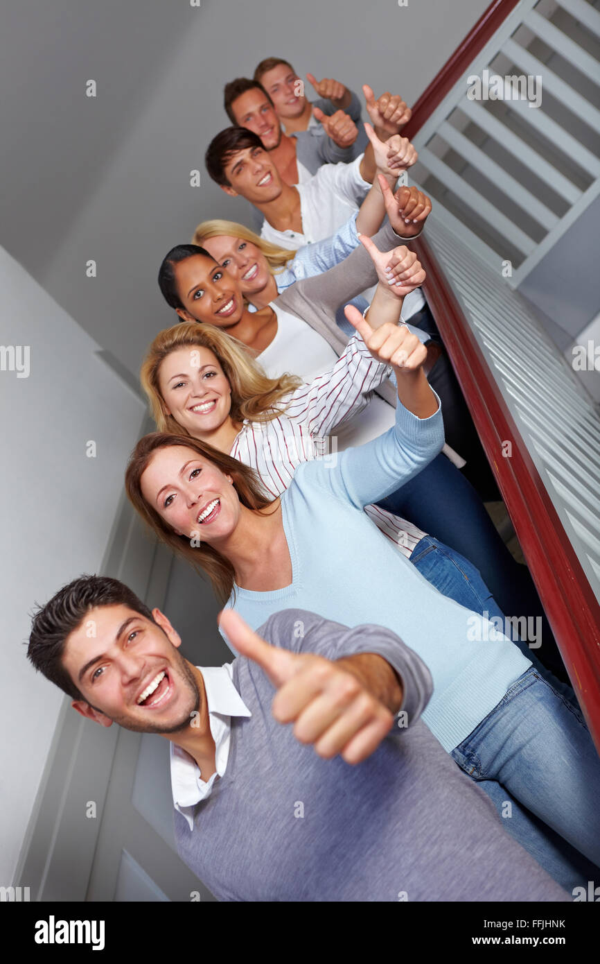Successful students at university holding their thumbs up Stock Photo ...
