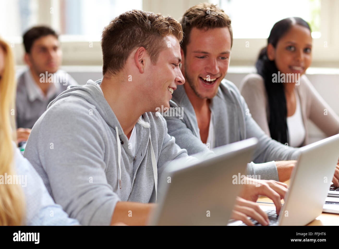 Two happy students chatting in university class Stock Photo