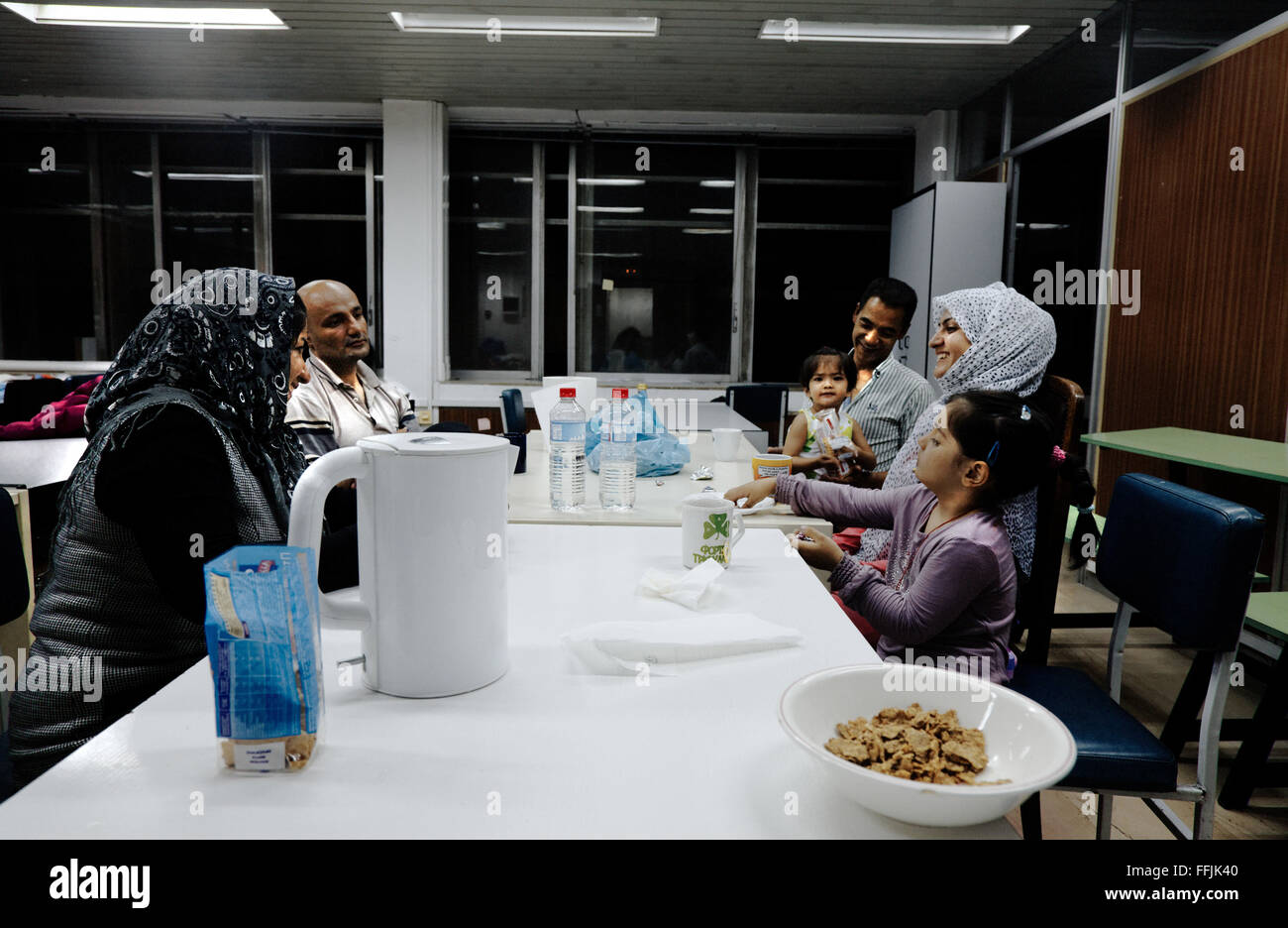 07/10/2015  -  Greece / Athens  -  Refugees have a late snack in the dining room of Notara 26. Stock Photo