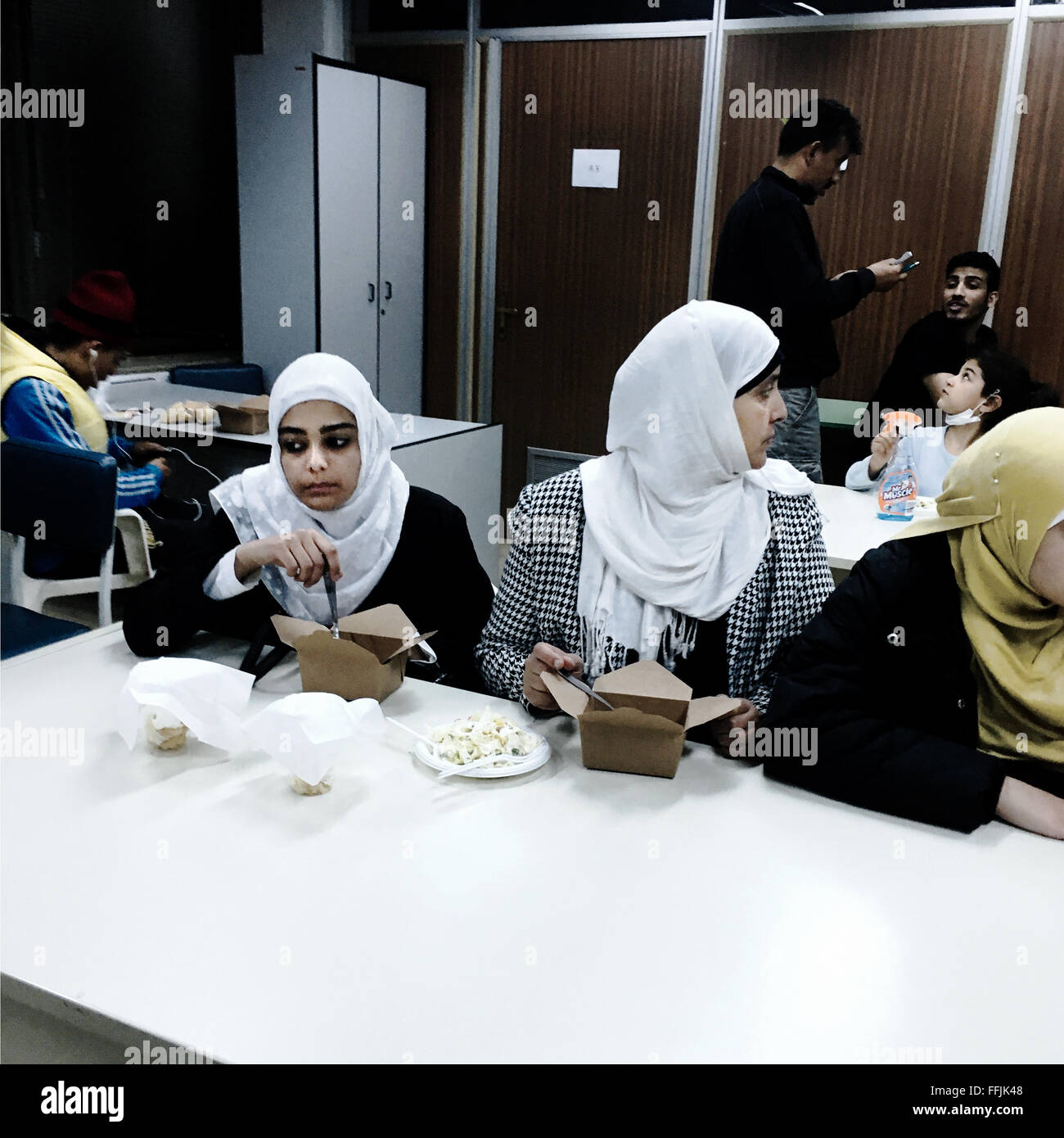 Young refugees eat in the dining room in Notara 26. The dinner was cooked from the collective kitchen Nosotros. Stock Photo