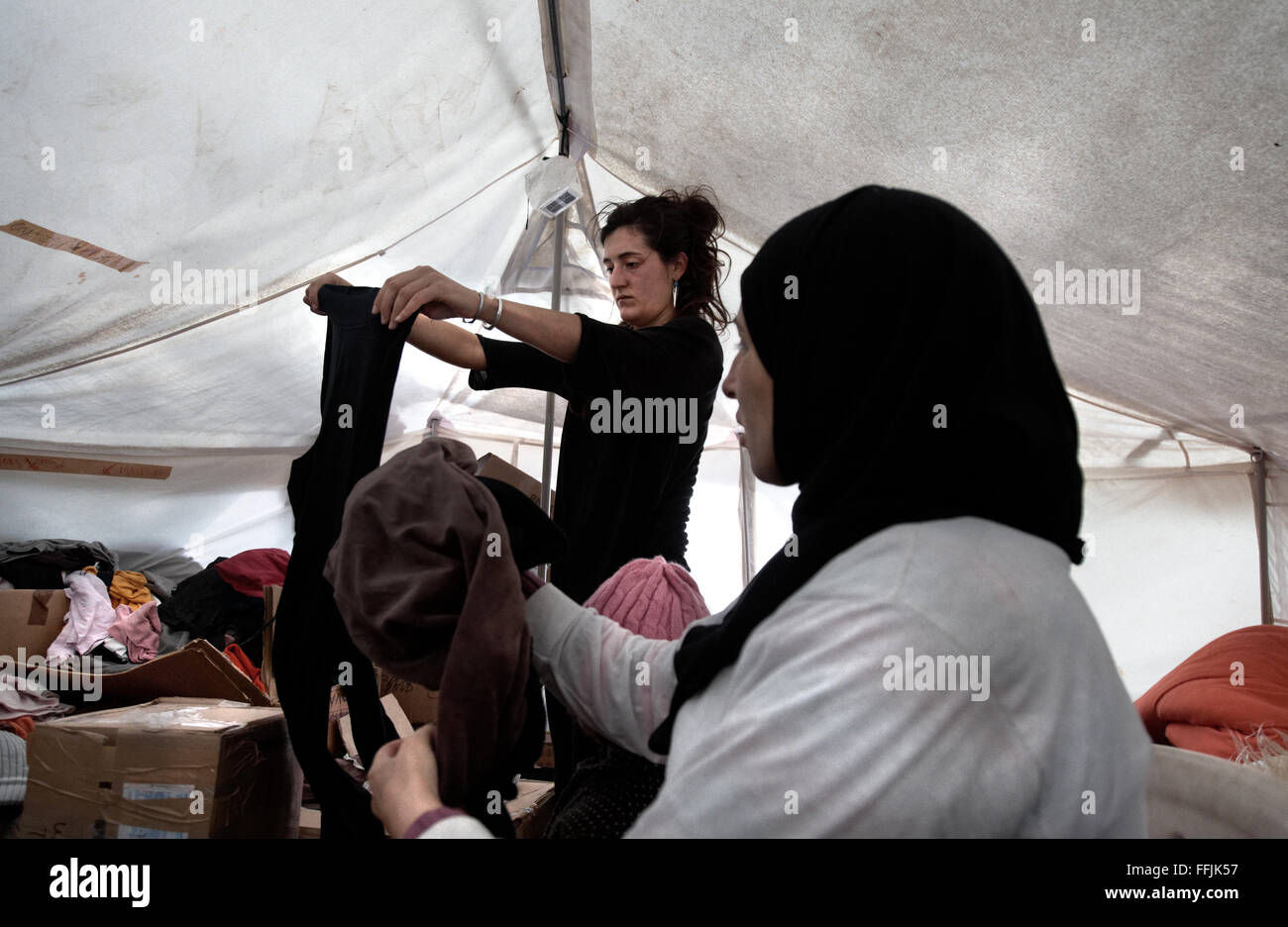 Jenia from Spain helps a refugee change her wet clothes in Platanos camp, after having crossed the 7,5 miles of sea Stock Photo
