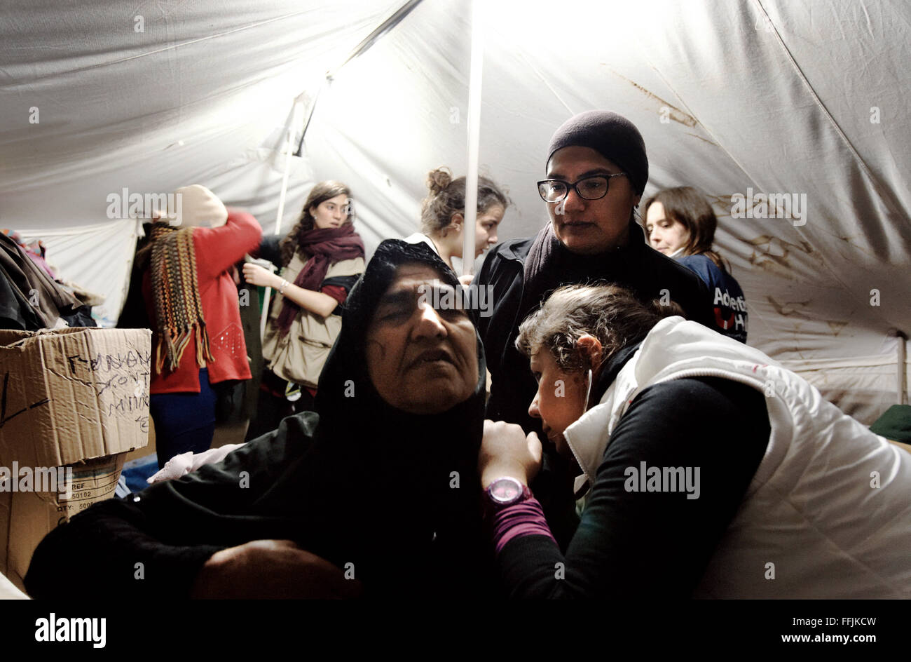 Doctor examines an elederly woman from Afganistan in the women's tent in Platanos. Stock Photo