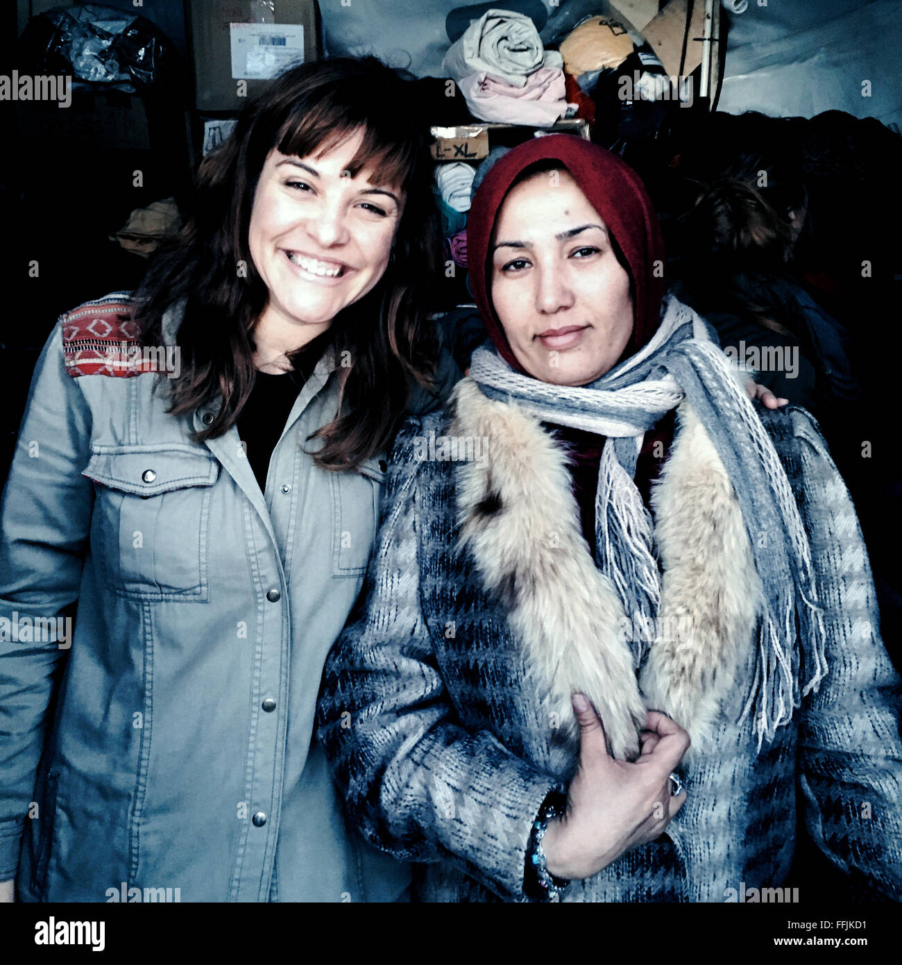 Teresa from Spain (left) and a Syrian woman (right) dressed by her, stand in front of the women's tent. Stock Photo