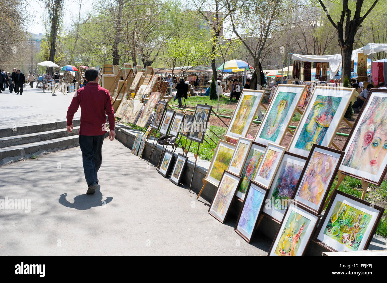 Man walking past art for sale at the Vernissage open-air flea market, Yerevan, Armenia Stock Photo