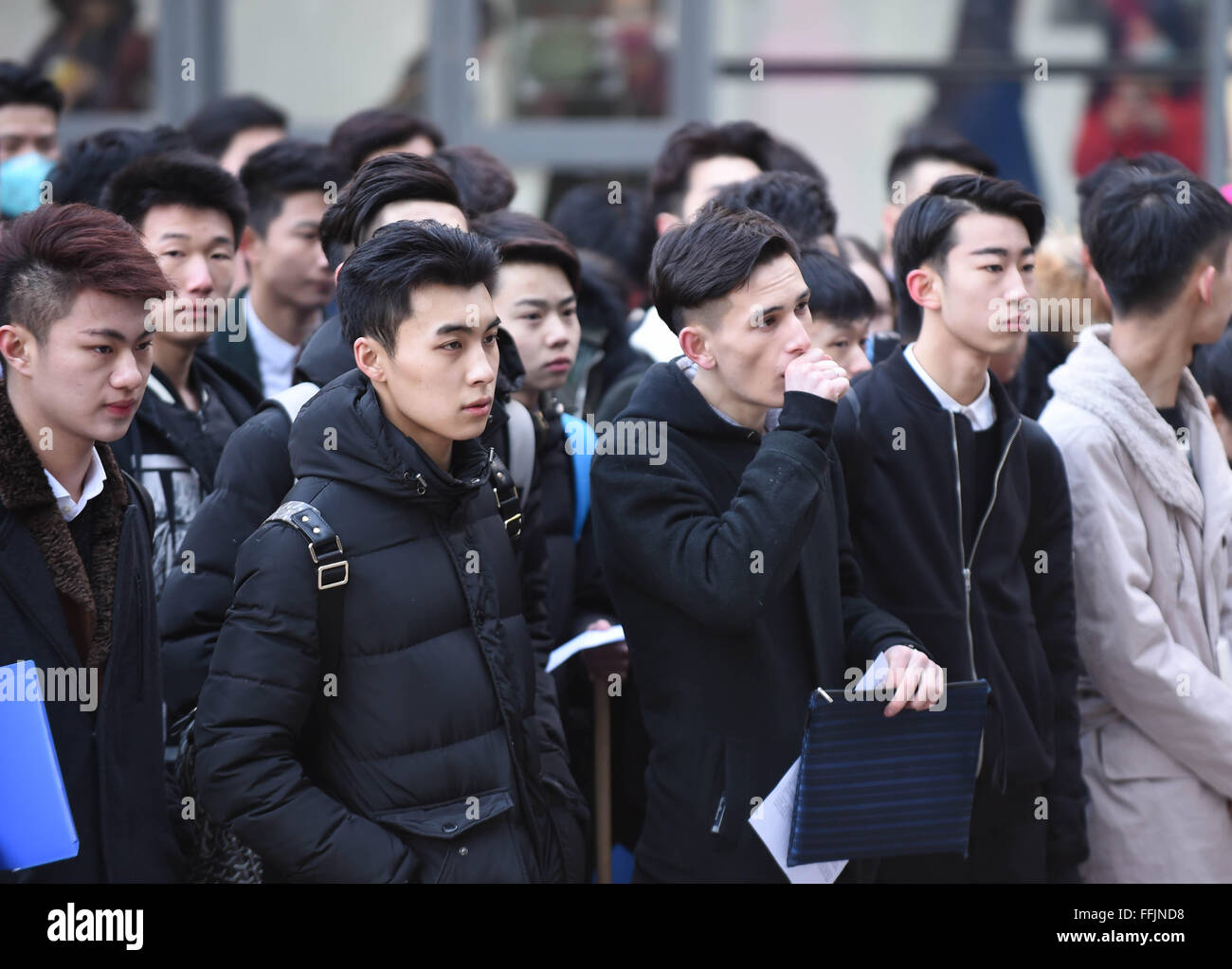 Beijing, China. 15th Feb, 2016. Candidates wait outside the examination hall at Beijing Film Academy (BFA) in Beijing, capital of China, Feb. 15, 2016. The annual entrance exam of China's art colleges including BFA, the Central Academy of Drama and the Communication University of China started simultaneously on Monday. Over 7,600 applicants for BFA's performance institute will take part in the exam to vie for 45 vacancies in the institute. Some Chinese young people regarded studying in an art college as a shortcut to become famous in recent years. © Li Wen/Xinhua/Alamy Live News Stock Photo