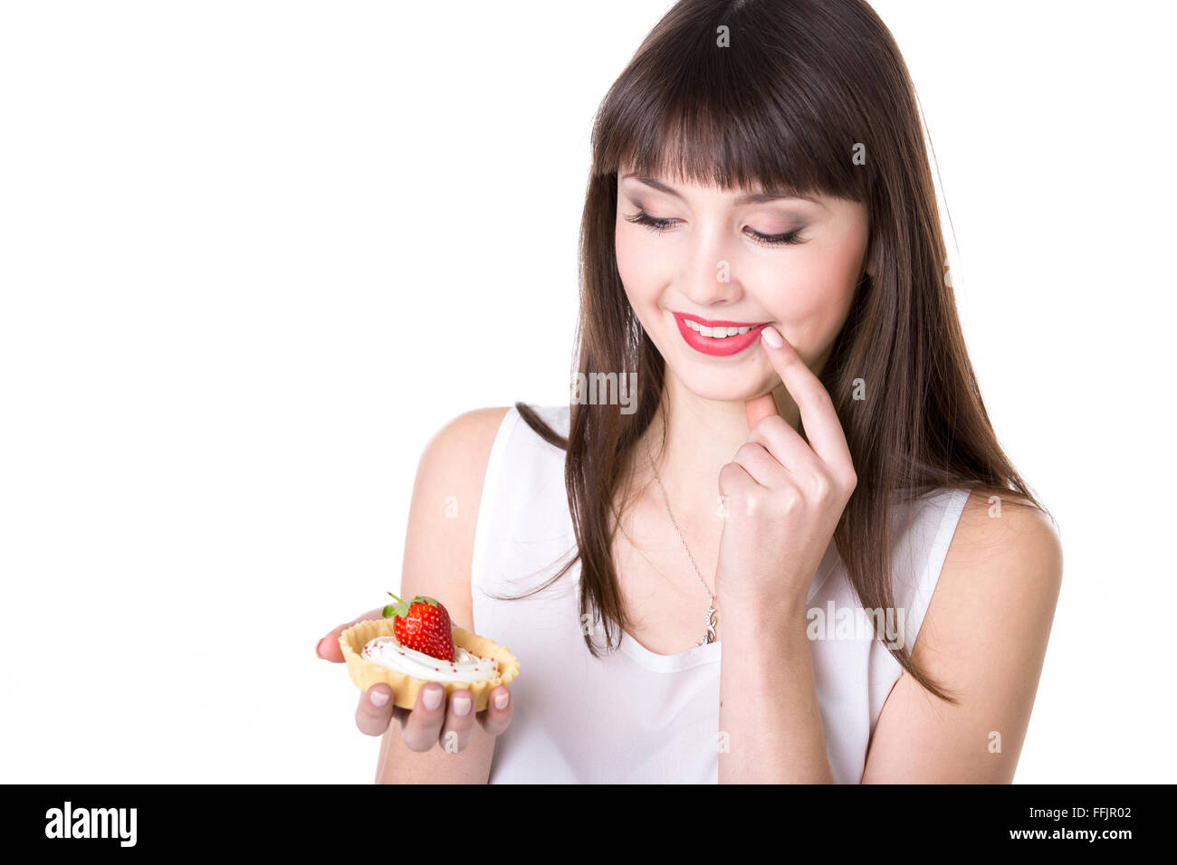 Young smiling woman holding in her palm delicious strawberry tart cake