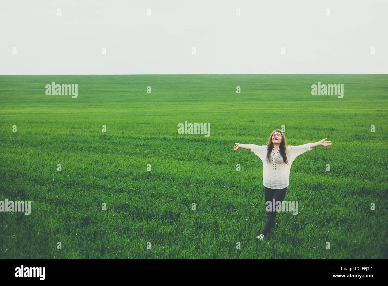 Happy young woman in green field Stock Photo - Alamy