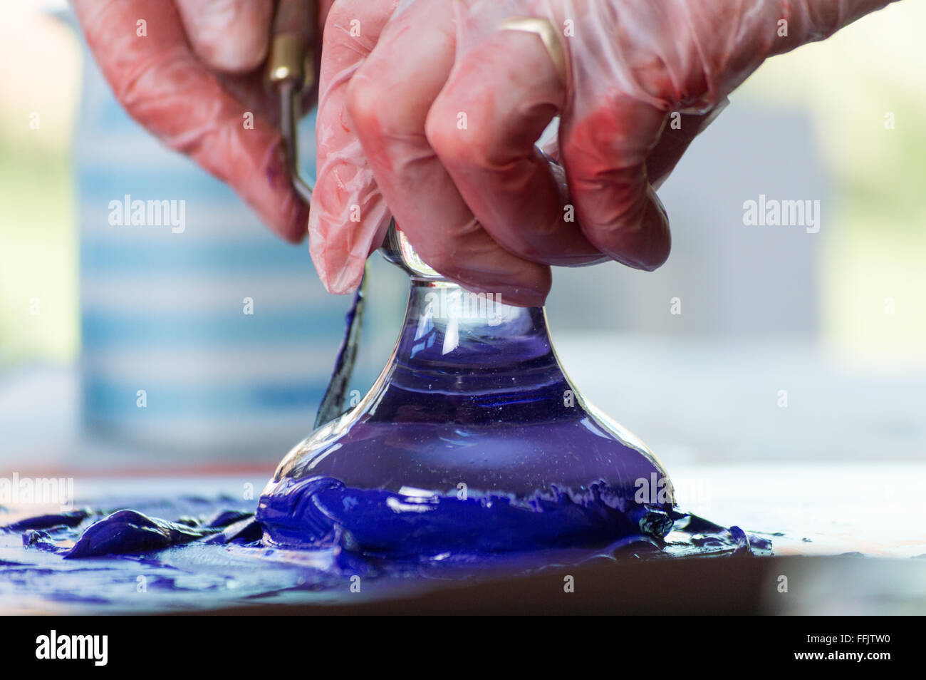 Grinding blue paint pigments using a glass muller Stock Photo Alamy