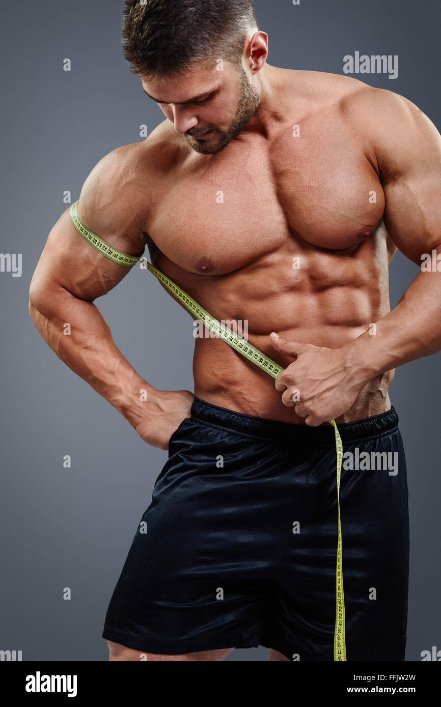 Bodybuilder measuring biceps with tape measure Stock Photo