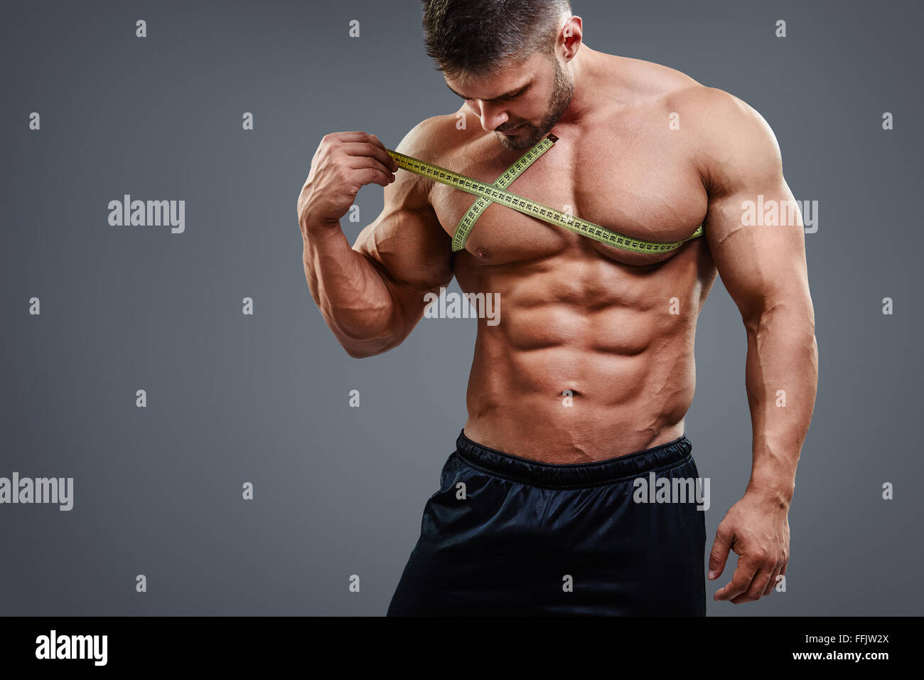 Bodybuilder measuring chest with tape measure Stock Photo