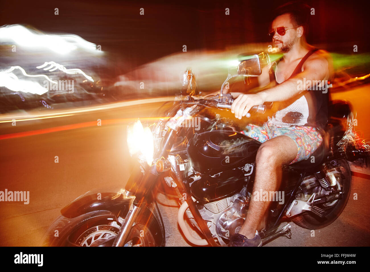 Young man on a motorcycle in night Stock Photo