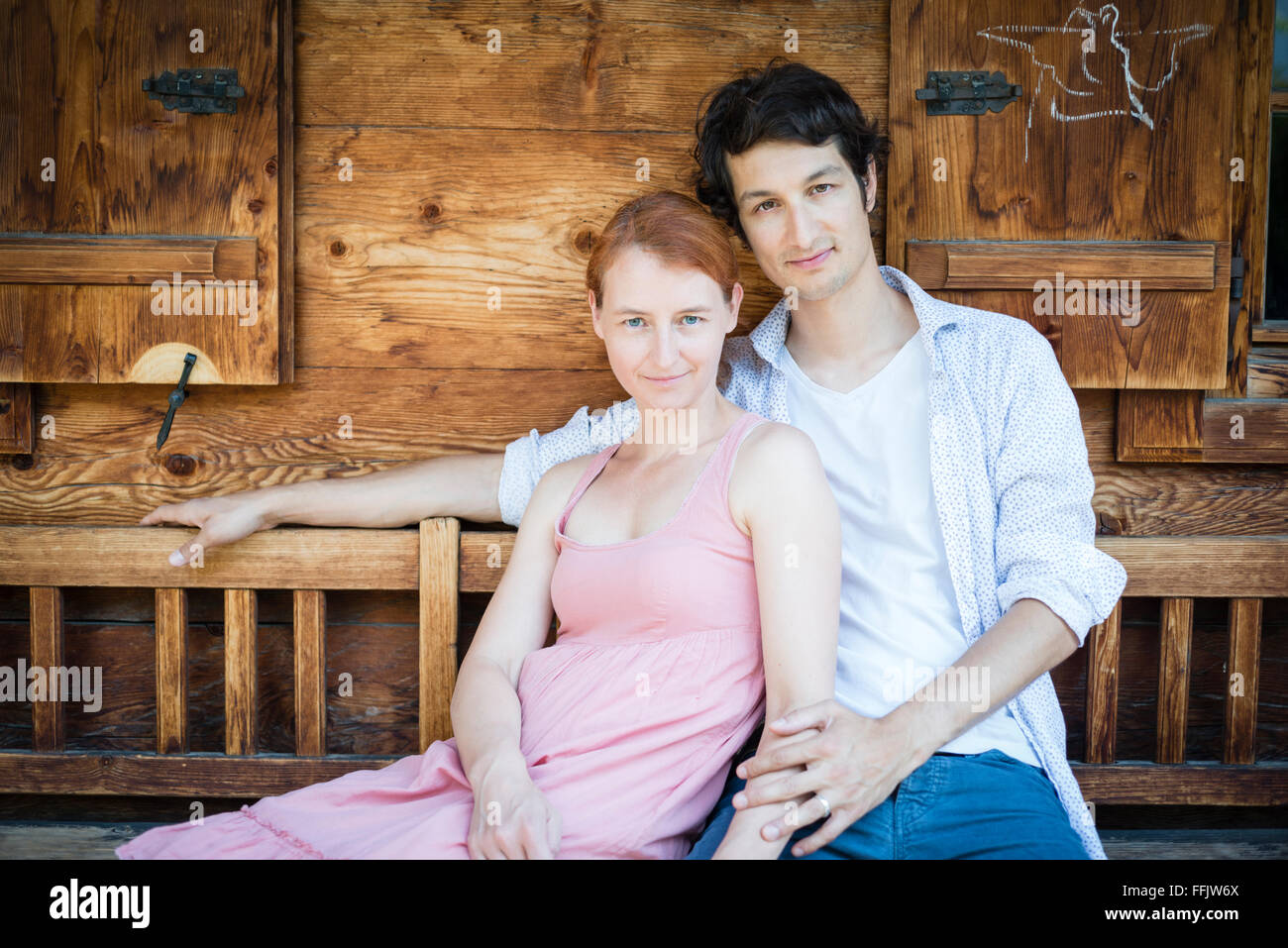 Portrait of happy couple sitting side by side Stock Photo