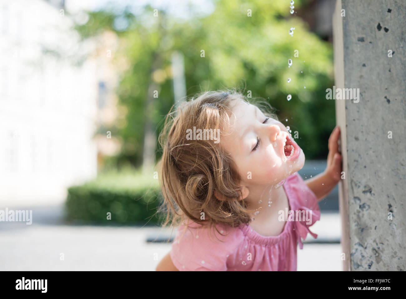Little girl drinking water from fountain Stock Photo