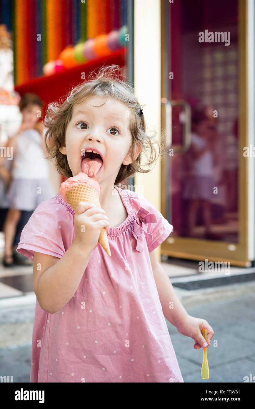 Little girl eating ice cream cone outdoors Stock Photo