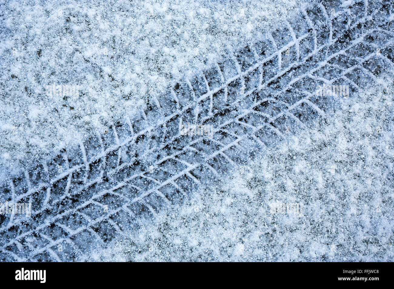 Tire tracks in snow - driving in winter weather Stock Photo