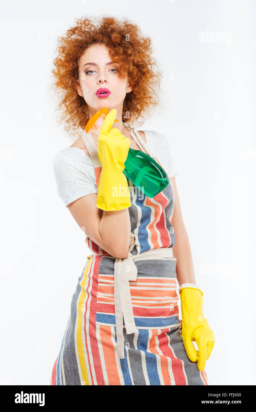 Confident playful young woman in striped apron and yellow gloves posing ...