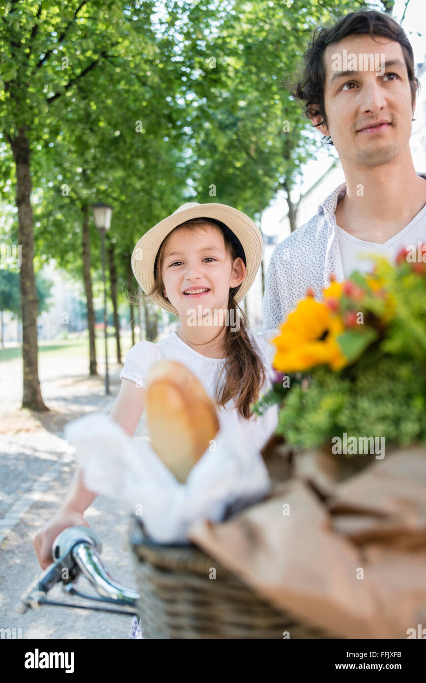 Father and daughter with bicycle and flowers Stock Photo