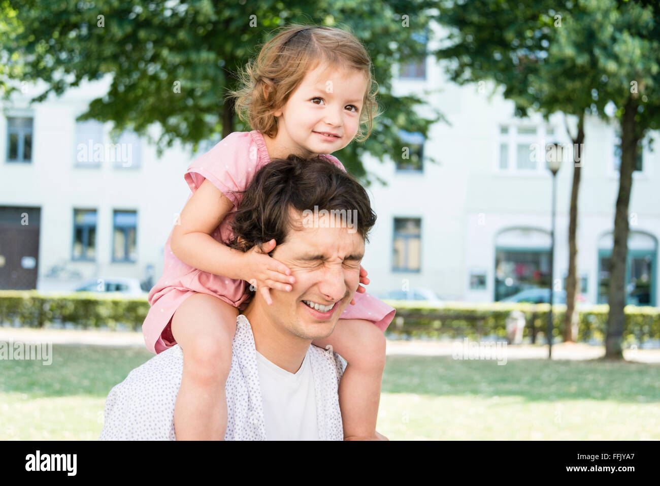 Father carrying daughter on shoulders Stock Photo