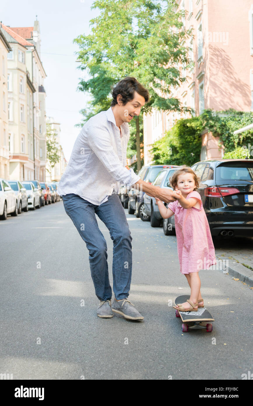 Father and daughter on skateboard Stock Photo