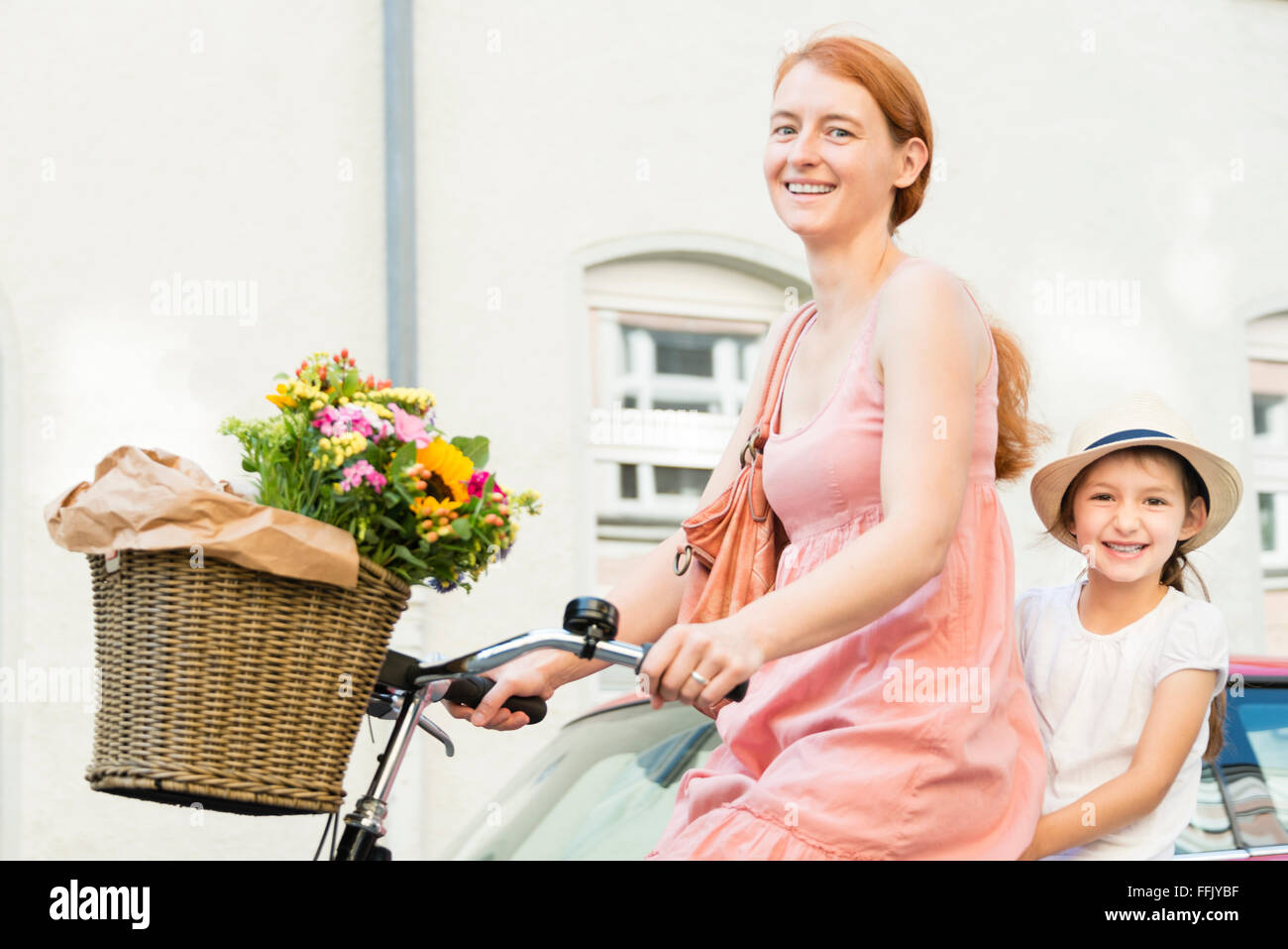 Mother and daughter cycling in city Stock Photo