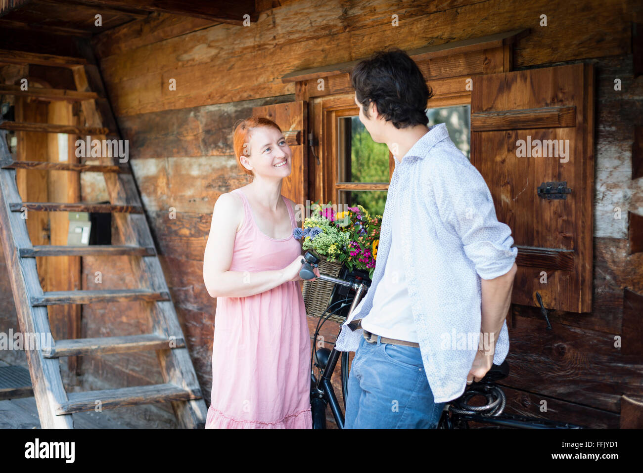 Happy couple in front of log cabin Stock Photo
