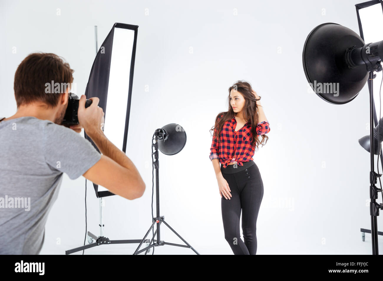 Photographer shooting model in professional studio with softboxes Stock Photo