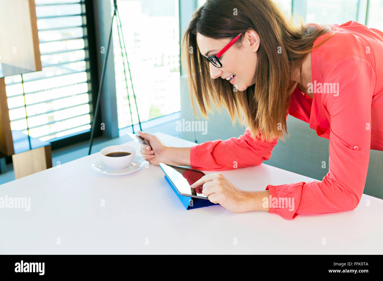 Woman in apartment shopping online with digital tablet Stock Photo