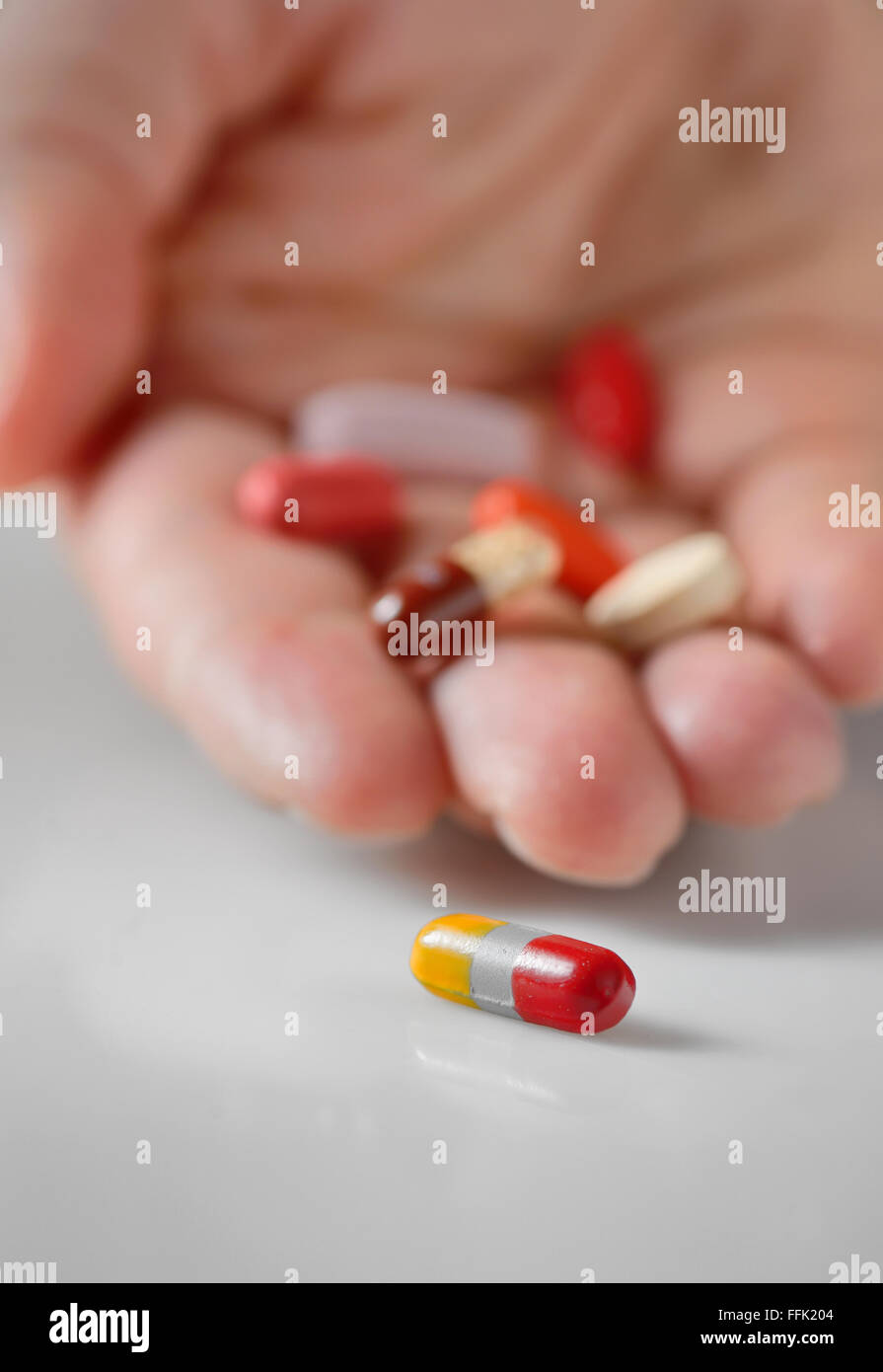 Hand taking the pill isolated Stock Photo