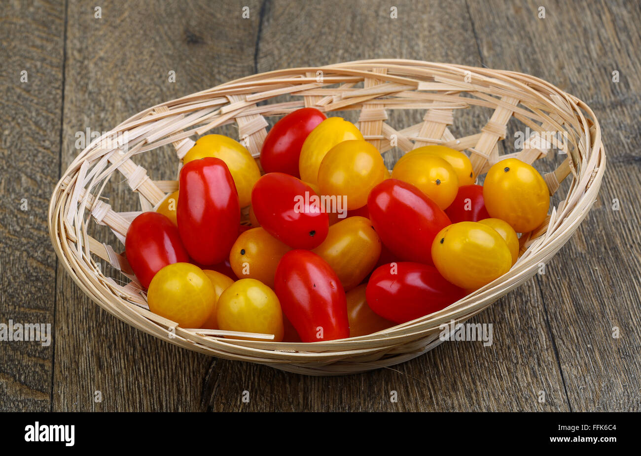 Yellow and red cherry tomatoes mix on the basket Stock Photo - Alamy