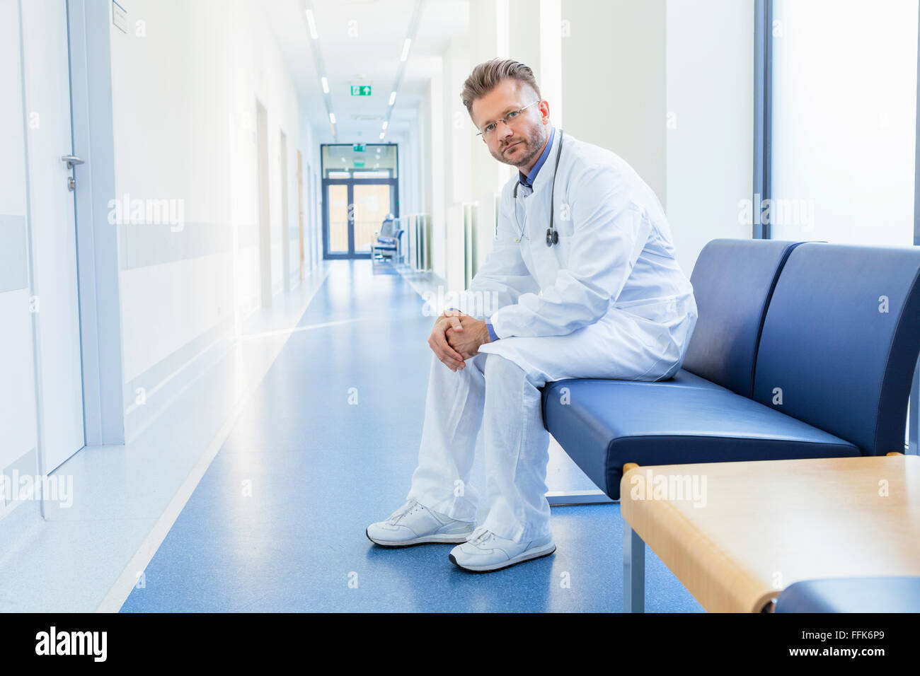 Doctor takes a break sitting in hospital corridor Stock Photo