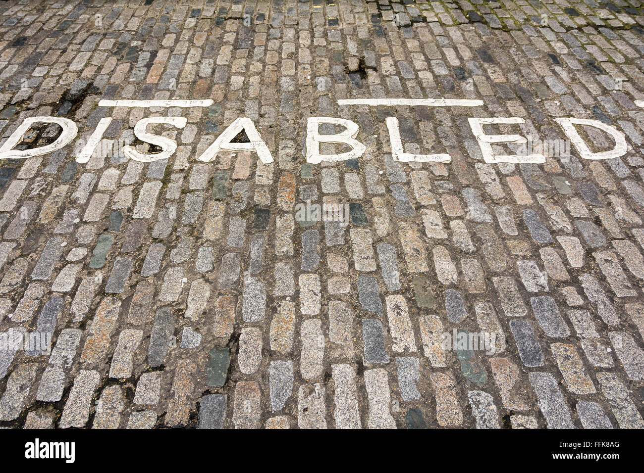 Painted disabled sign in parking bay, on a cobbled street, in London, UK Stock Photo