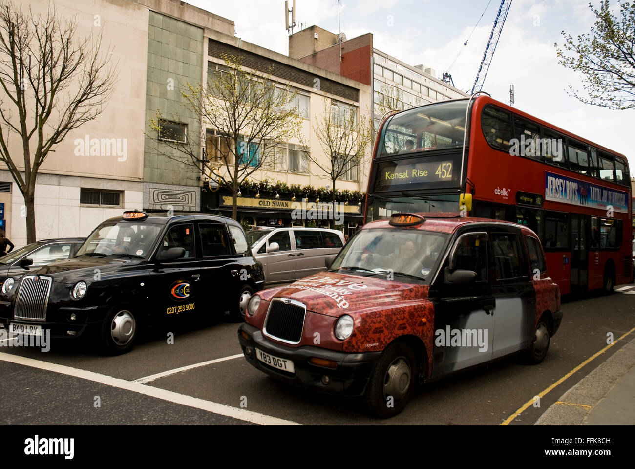 Double decker red bus and traditional London taxi cabs in Kensington Church St, London, United Kingdom Stock Photo