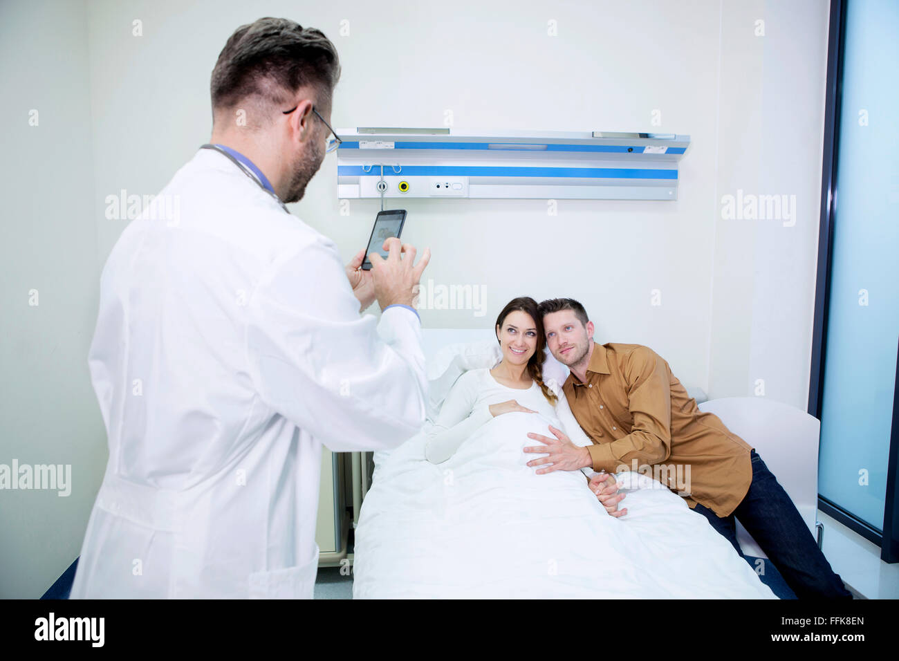 Doctor taking a picture of patient and boyfriend Stock Photo