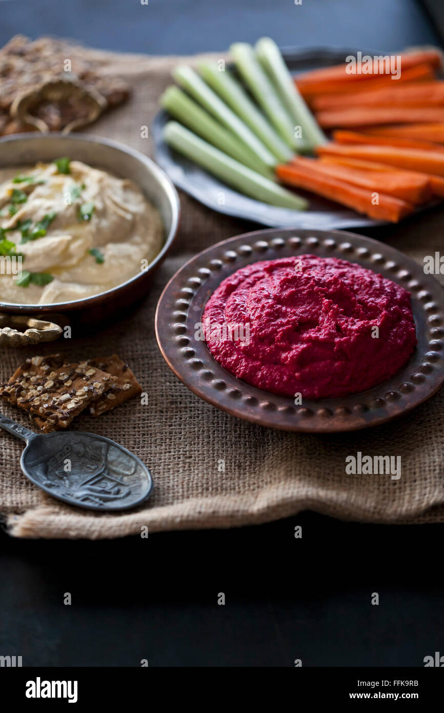 Hummus and beetroot hummus with crisp bread, carrots and celery Stock Photo