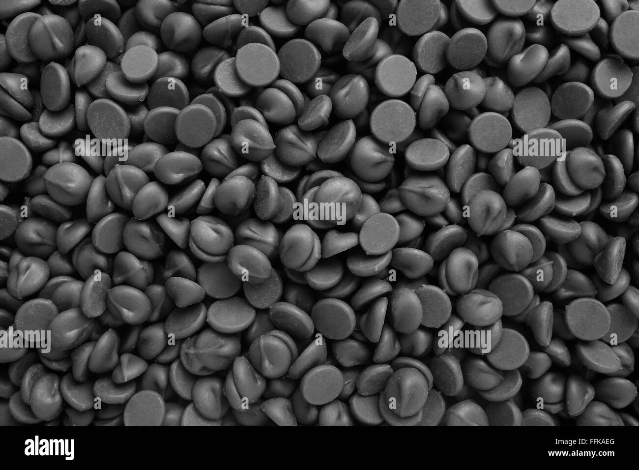 Milk chocolate chips as an abstract background texture - monochrome processing Stock Photo