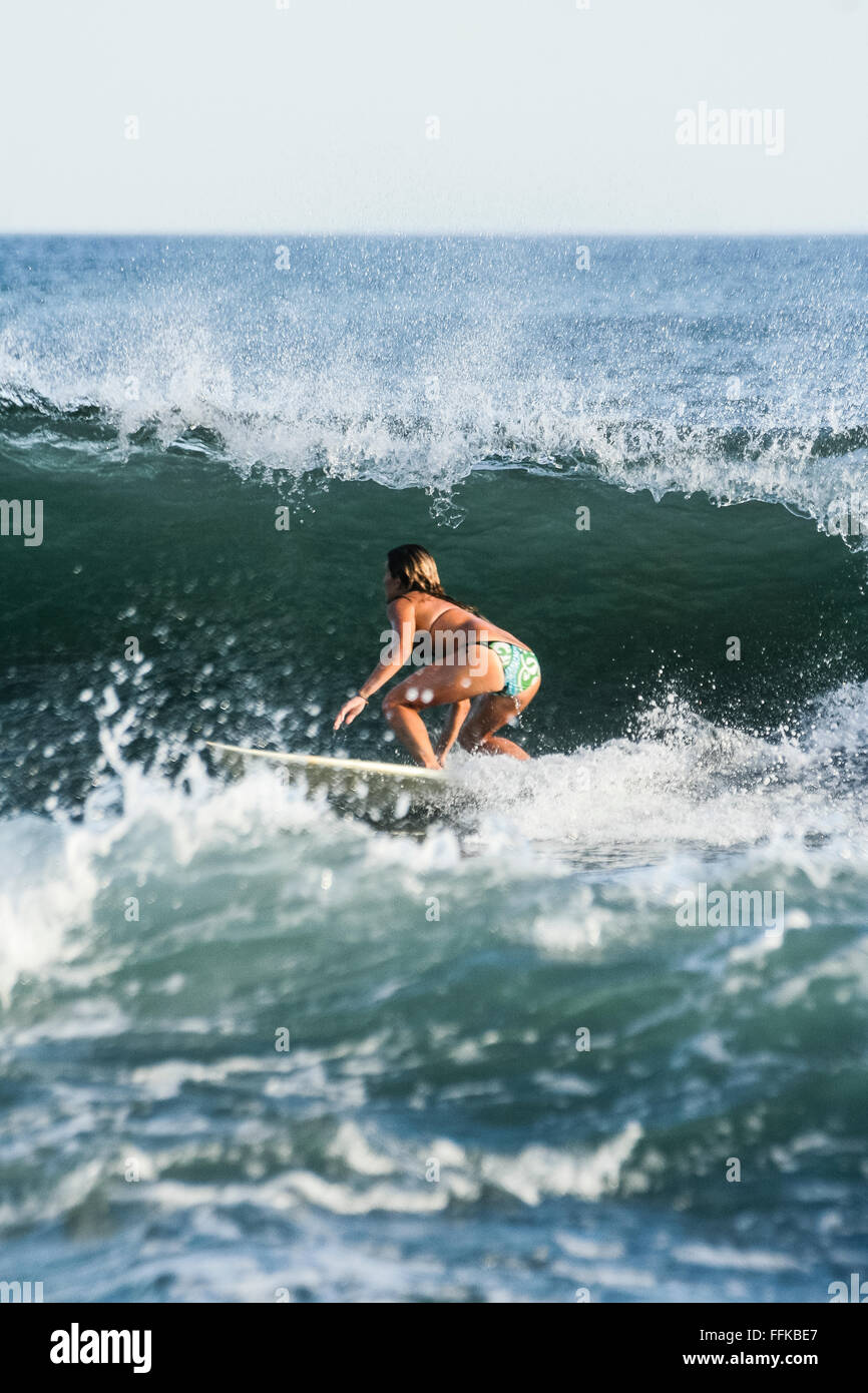 Playa el Zonte, El Salvador. Woman on surfboard among breaking waves