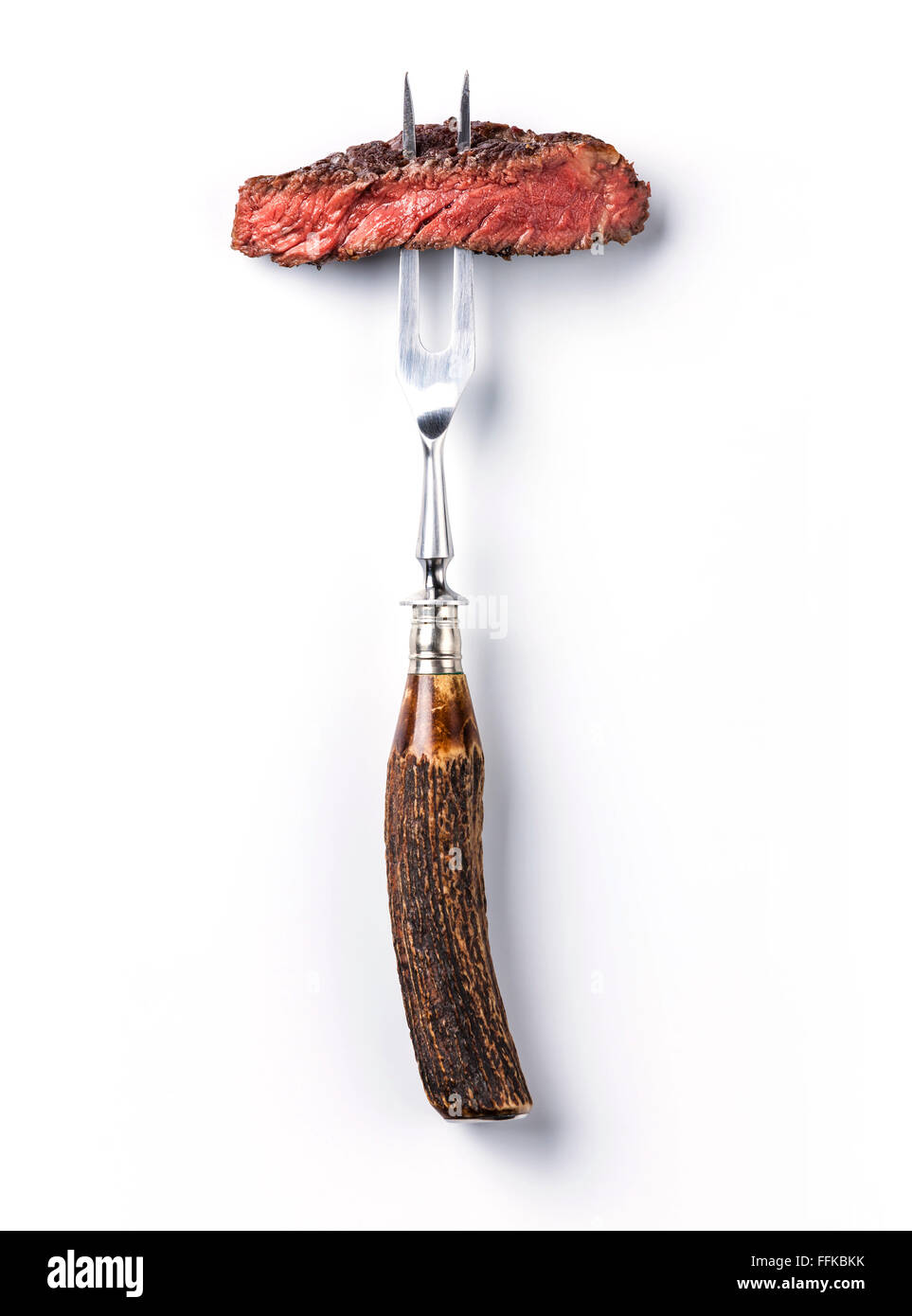 Sliced beef steak ribeye on meat fork on white background Stock Photo