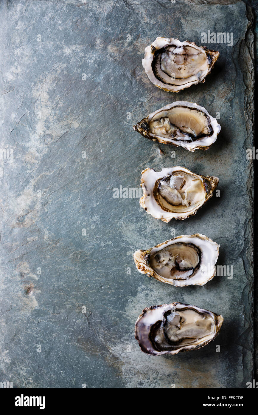 Open oysters on stone plate background Stock Photo Alamy