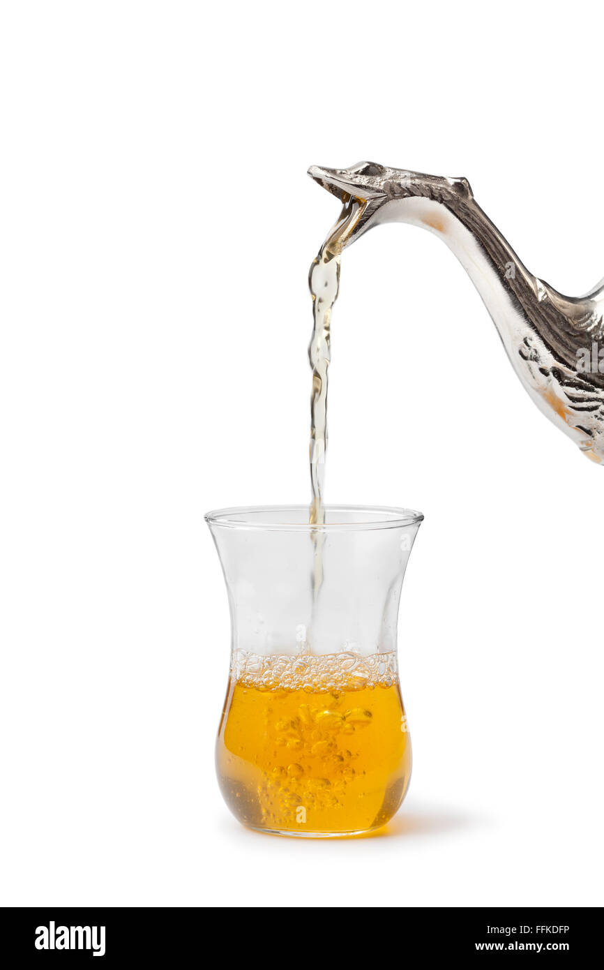Traditional Moroccan mint tea poured in a glass on white background ...
