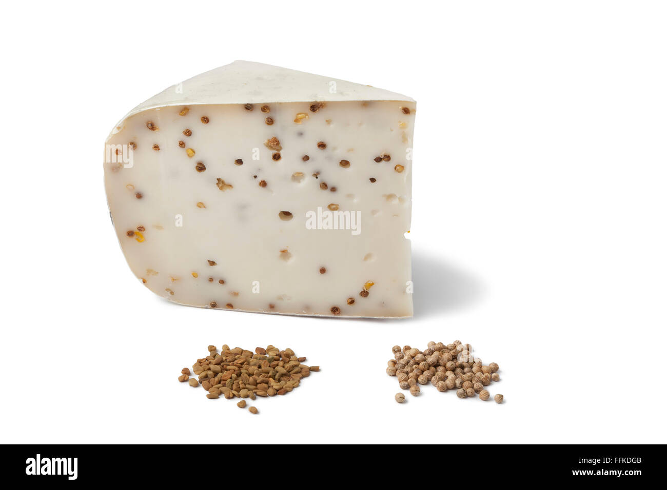 Piece of Goats cheese with Coriander and Fenugreek on white background Stock Photo