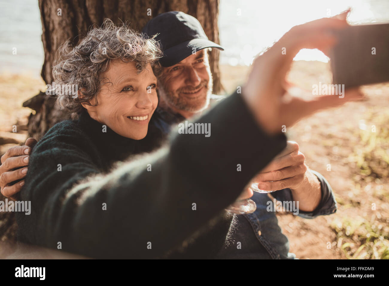 Happy senior couple taking their self portrait with their cell phone on ...