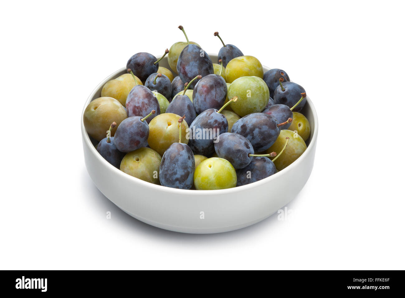 Bowl with fresh Damson and Reine Claude plums on white background Stock Photo