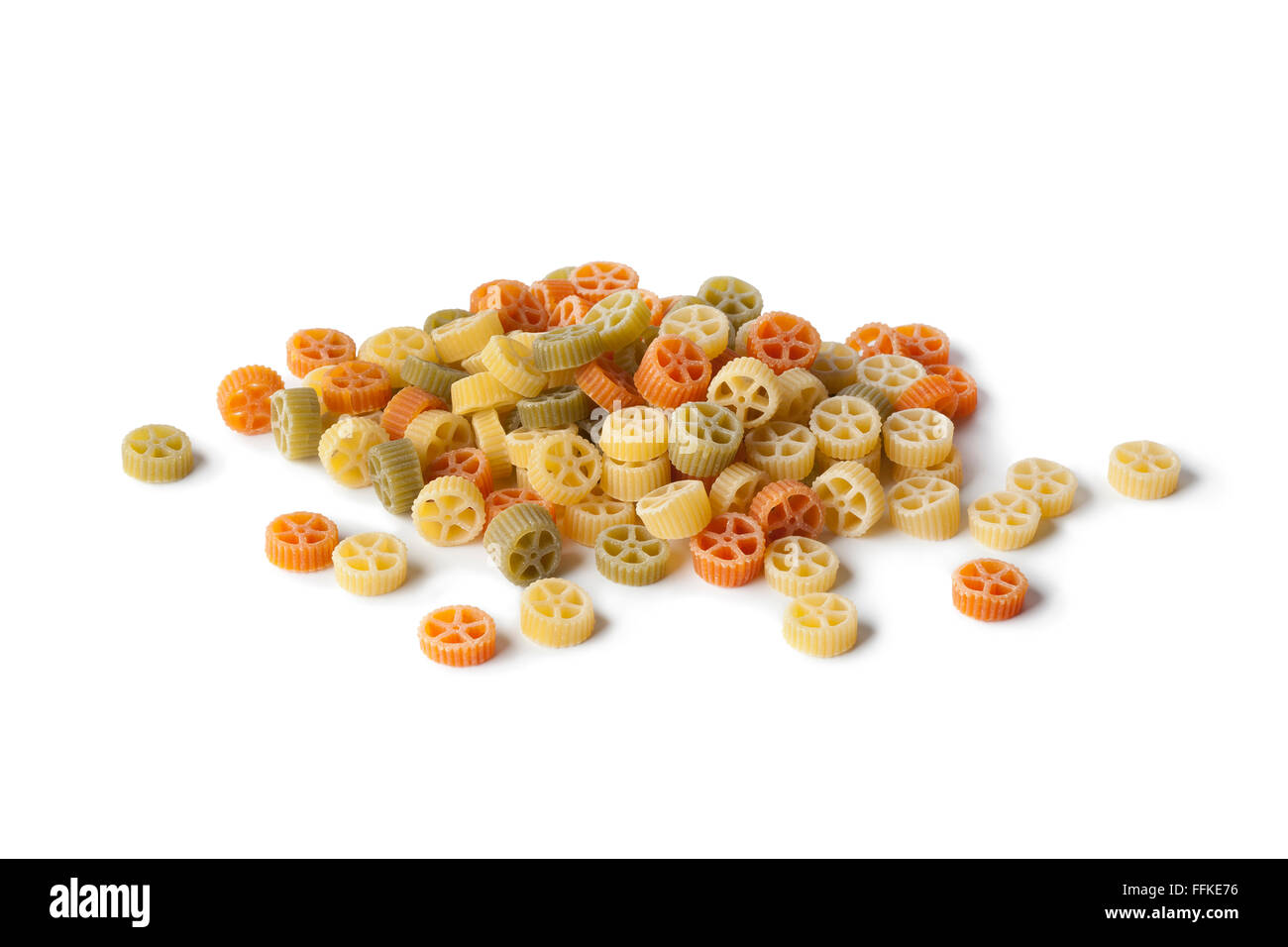 Colored raw wheel pasta on white background Stock Photo