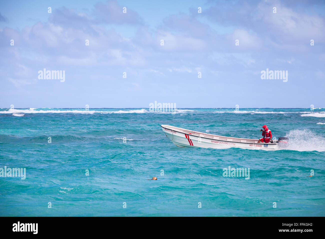 Punta Cana, Dominican republic - January 11, 2015: White pleasure motorboat with local driver goes along the beach in Punta Cana Stock Photo