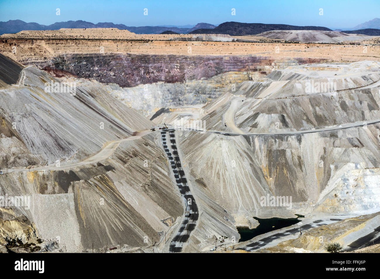view of Mission open pit copper mine near Tucson from tour overlook with water collected at the deepest level, 1/4 mile down Stock Photo