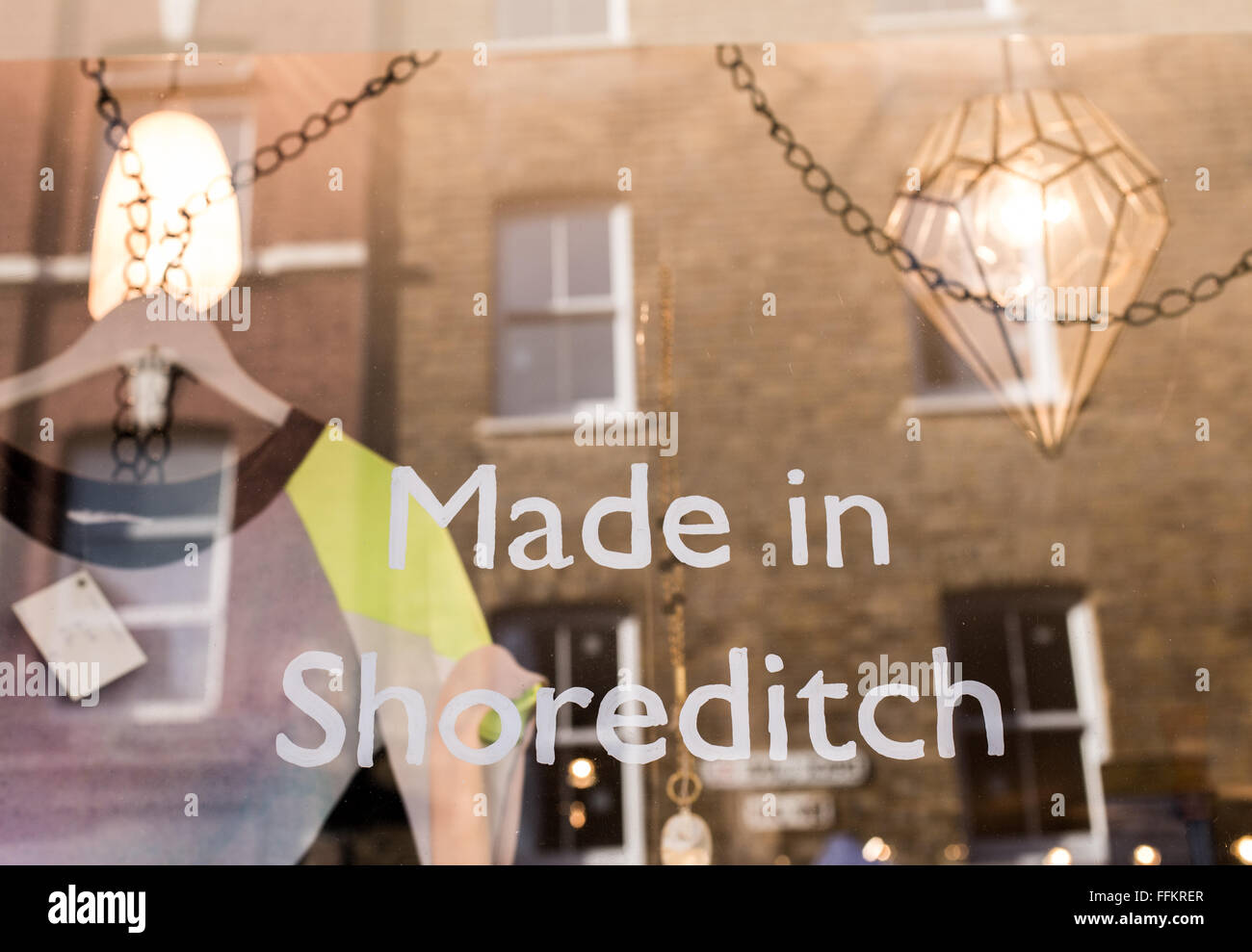 Shop window with the writing 'Made in Shoreditch' in the trendy area of East London. T-Shirt hanging inside and reflection of a Stock Photo