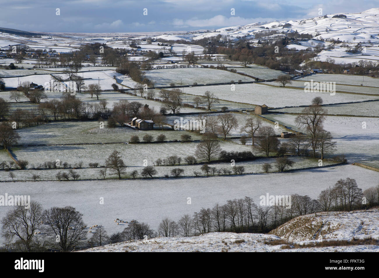 Snow dusted farmland in Upper Teesdale in County Durham, England. Dry stone walls divide the fields. Stock Photo