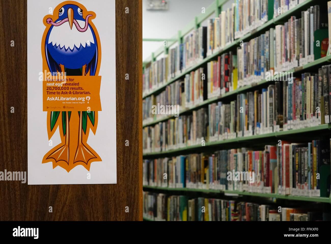 Poster promoting 'Ask-a-Librarian' and crowded bookshelves st the Ormond branch of the Volusia Public Library Stock Photo