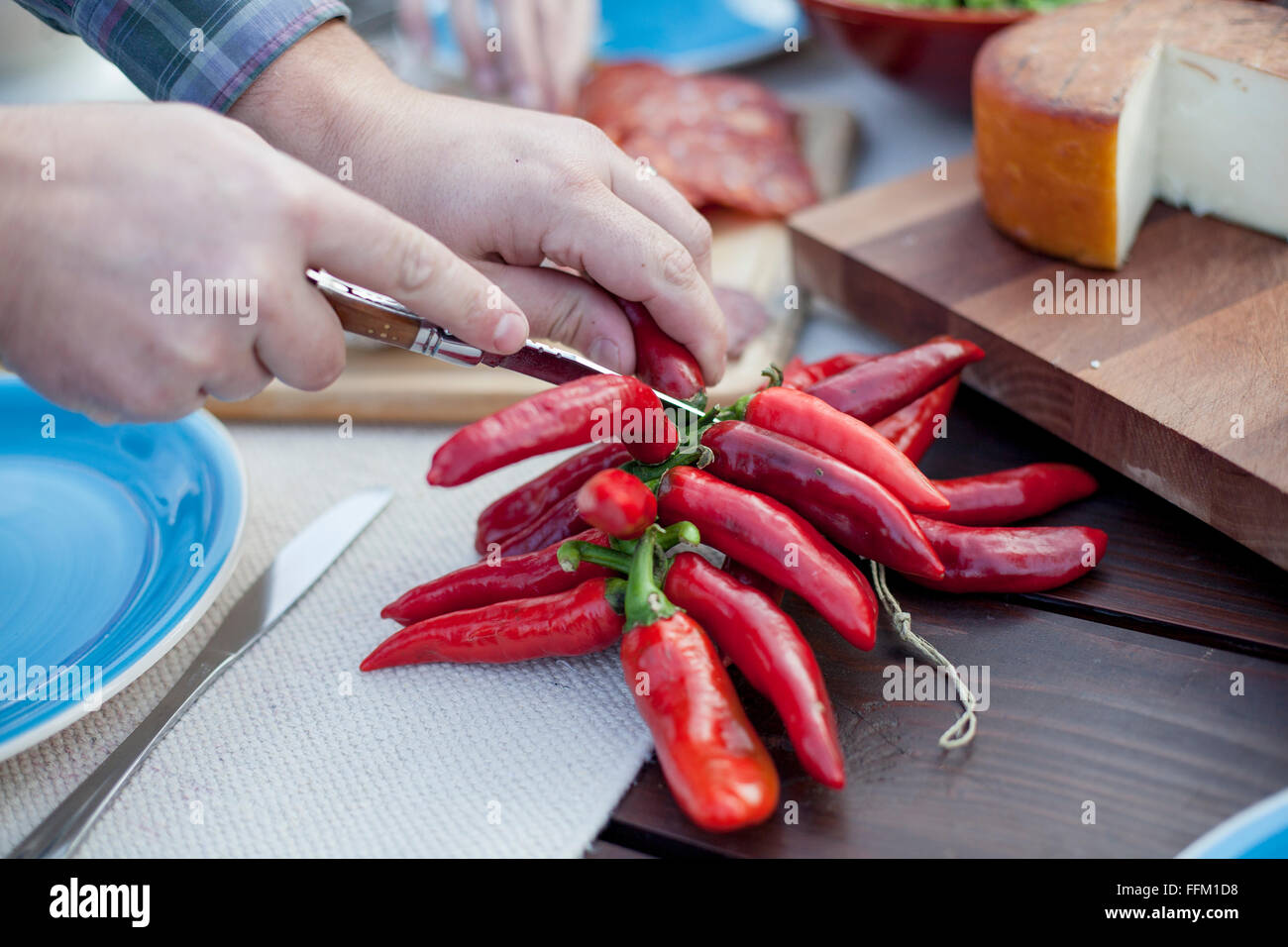 Person on garden party slicing red pepper Stock Photo