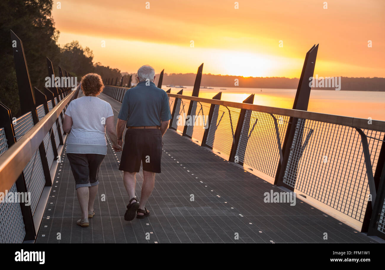 older couple walking at sunset Stock Photo